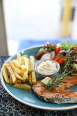 Roasted salmon steak , baked salmon with salad fresh vegetable pm wooden table
