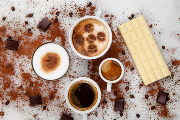 Different types of coffe ,espreso,long coffe ,latte,coffe with milk,on sweet background with coffe beans and chocolate.