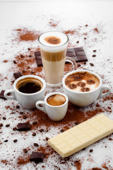 Different types of coffe ,espreso,long coffe ,latte,coffe with milk,on sweet background with coffe beans and chocolate.
