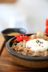 Japanese food Gyudon Japanese beef on rice bowl topped with egg on wooden table