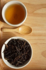 Tea in a white cup on wooden floor, Drink hot tea in the morning with light sunshine..