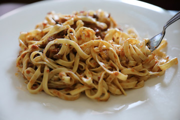 spaghetti Bolognese with minced beef and tomato sauce garnished with parmesan cheese and basil , Italian food