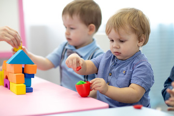 Children toddlers play colorful clay toy in kindergarten or daycare