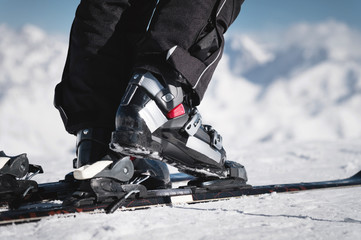 Close-up of the athlete's skier's foot in ski boots rises into the skis against the background of...