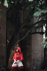 Fototapeta na wymiar Portrait young woman with Little Red Riding Hood costume in green tree park