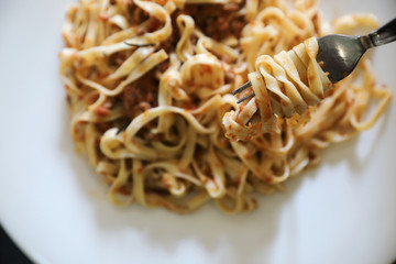 spaghetti Bolognese with minced beef and tomato sauce garnished with parmesan cheese and basil , Italian food