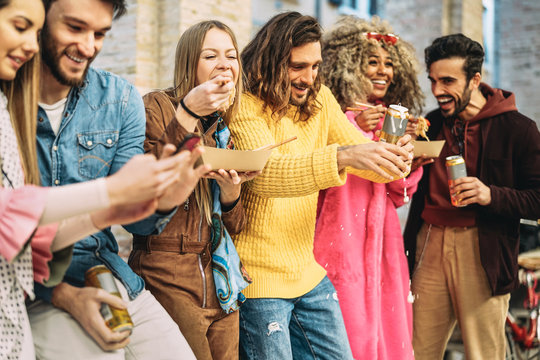 Group of happy friends eating Asian food and drinking beers in the city - Millennial young people having fun and laughing together outdoor - Friendship, social and youth lifestyle concept