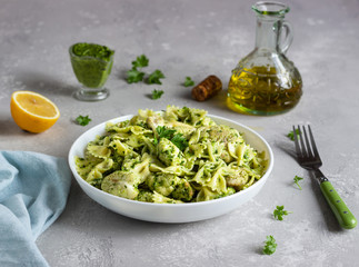 Pasta with green sauce and roaster cauliflower on a white plate. Copy space.