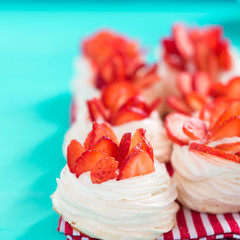 Beautiful pavlova cakes with strawberries on a blue background. Selective focus. Tasty sweet breackfast. Wedding morning. Meringue with cream.