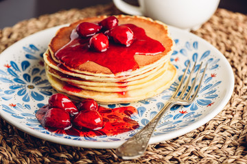 Stack of pancakes with cornelian cherry jam on plate