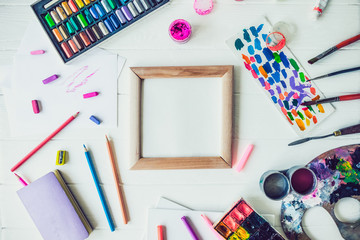Top view Bright workplace of creative artist mockup. Blank canvas surrounded by variety of drawing supplies. Art, workshop, painting, drawing, inspiration, craft, creativity concept. Art therapy,