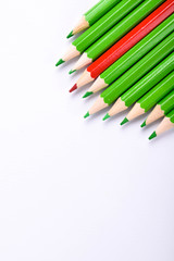 Many different colored pencils on a white background with a place for text and cory space .