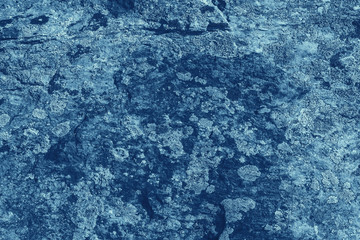 Vintage blue background. Rough painted wall of sapphire color. Imperfect plane of blue colored. Uneven old decorative toned backdrop of cyan tint. Texture of sapphirine hue. Ornamental stony surface.