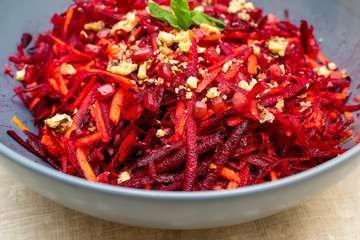 Salad of grated red beets carrots pomegranates and walnuts