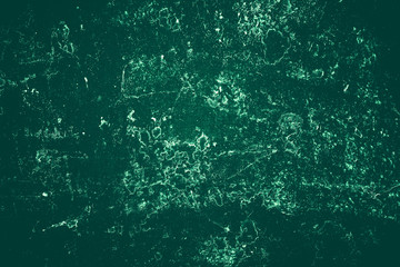 Vintage green background. Rough painted wall of emerald color. Imperfect plane of virid colored. Uneven old decorative toned backdrop of green tint. Texture of emerald hue. Ornamental stony surface.