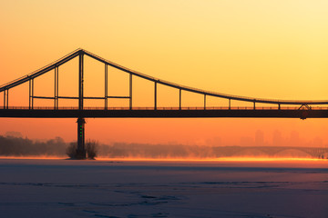 Fototapeta na wymiar Frosty morning at the river near the bridge