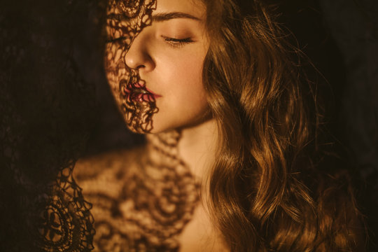 lace and shadows. Sensual sexy portrait of a young woman. Beautiful long hair.