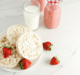 healthy rice waffles like breakfast, snacks and fresh strawberries, strawberry smoothies and a glass of milk on marble table, background. copy space