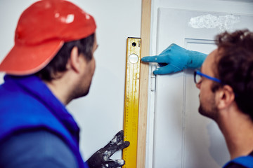 Two handymen working together on a house renovation.