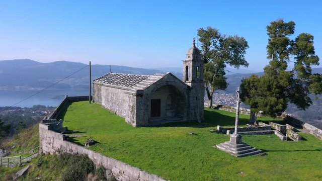 Aerial dolly forward reveal Redondela town over old hilltop Peneda chapel, Spain