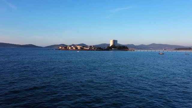 Aerial dolly forward approaching Toralla private Island in Vigo, Spain at sunset