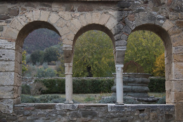 Historical arches. Remains of a historic building with a well in the background 