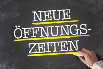 text NEUE ÖFFNUNGSZEITEN, German for new opening hours or changed business hours, written on blackboard