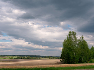 Fototapeta na wymiar bad weather clouds over the spring field