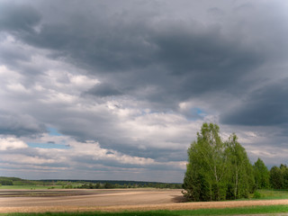 Fototapeta na wymiar bad weather clouds over the spring field
