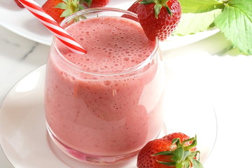 Strawberry smoothie or milkshake in a glass  close up top view on white background. Healthy food for breakfast and snack. copy space