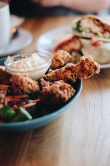 Crispy chicken with mayo sauce on a wooden table