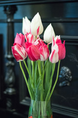 pink and white tulips in a vase on the piano background