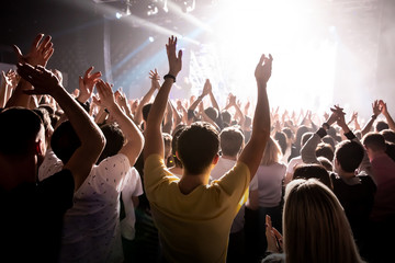 Raised hands in honor of a musical show on stage