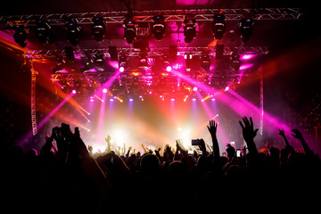 Raised hands in honor of a musical show on stage