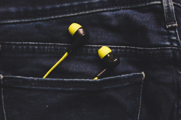 Headphones in the back pocket of jeans. Copy Space Background for advertising