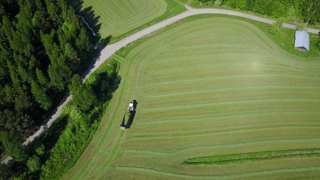 Aerial of chaser bin also called grain cart or auger wagon is trailer towed by tractor with a built-in conveyor system used for pickup of dried crops from land in this case grass