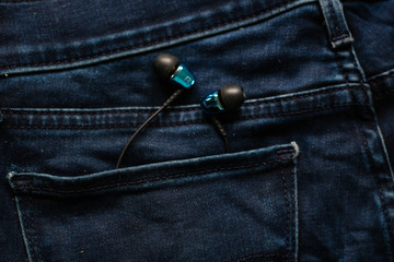 Headphones in the back pocket of jeans. Copy Space Background for advertising