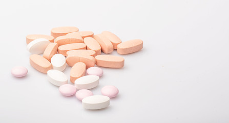 medical pink and white pills and capsules with medicine are on a white background