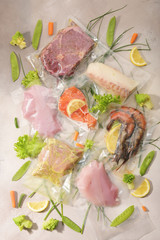 Sous Vide cooking concept. Vacuum packed ingredients arranged on light background.