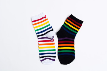 Two socks with colorful striped pattern with white and black textile on white background