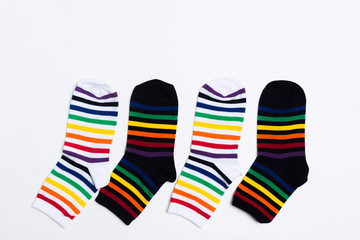 Four striped colorful fabric socks with white and black textile over white background