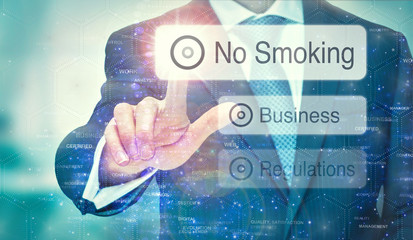 A business man selection a No Smoking button on a futuristic display with a concept written on it.
