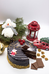 Delicious chocolate cake, decorated cherries, and sugar Santa and crispy nuts, with Christmas decor and ornaments.