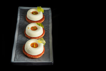 top view on three mini white mousse cakes with jam filling