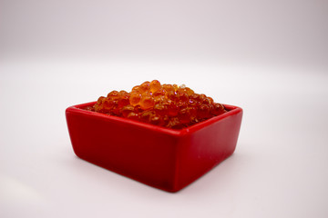 Luxury Red Caviar in the red bowl. Food photo concept.