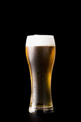 Beer glass in front of black background