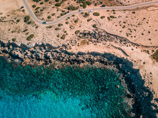 Aerial overhead Rocky seashore with crystal clear blue water near Cape Cavo Greco, Cyprus