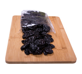 prunes in a package on a wooden board, background white