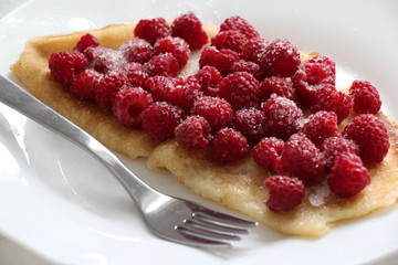 Delicious pancake with fresh raspberries on plate