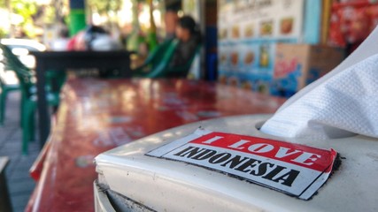 Sticker "I Love Indonesia" on plastic paper dispender in restaurant in Kuta, Bali.